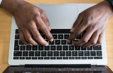Hände auf Laptop Tastatur