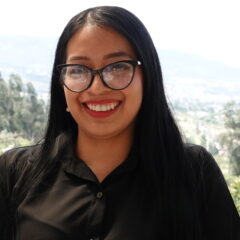 Woman with glasses smiling.